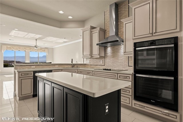 kitchen with a sink, wall chimney range hood, a peninsula, black appliances, and light countertops