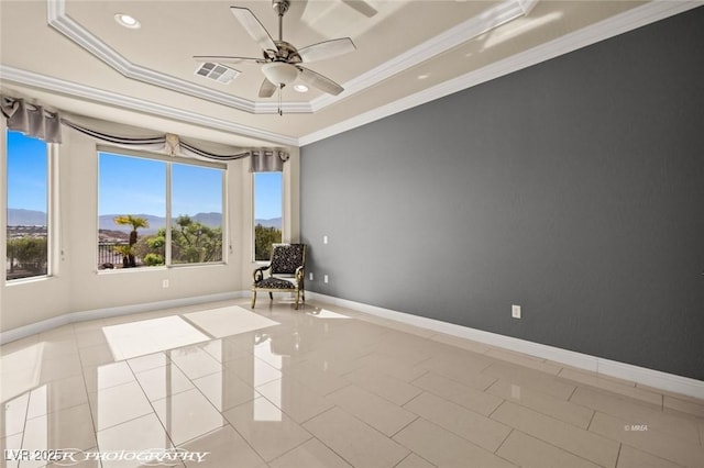 unfurnished room featuring a tray ceiling, light tile patterned floors, ornamental molding, visible vents, and ceiling fan