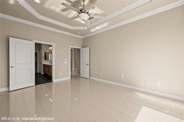 1348 Basin Vw, Mesquite, NV 89034 - unfurnished bedroom featuring a tray ceiling, crown molding, baseboards, connected bathroom, and light tile patterned flooring