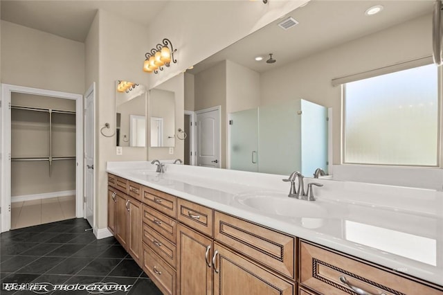bathroom featuring a shower stall, tile patterned floors, double vanity, and a sink