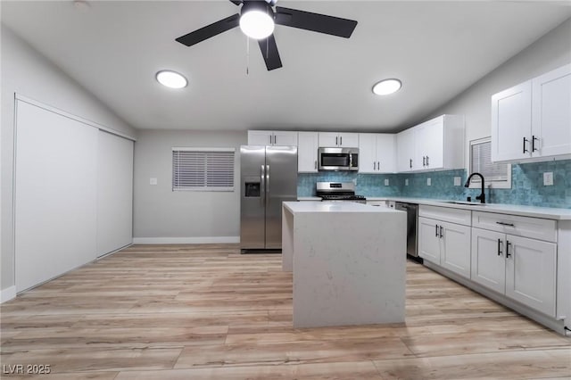 kitchen with a sink, light countertops, lofted ceiling, and stainless steel appliances
