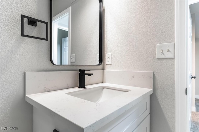 bathroom featuring a textured wall and a sink