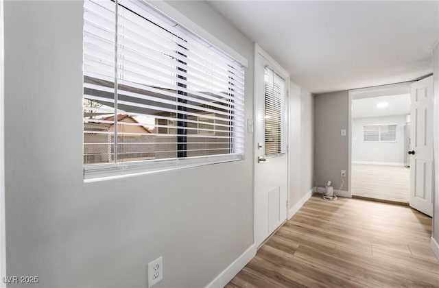 doorway to outside with baseboards and wood finished floors