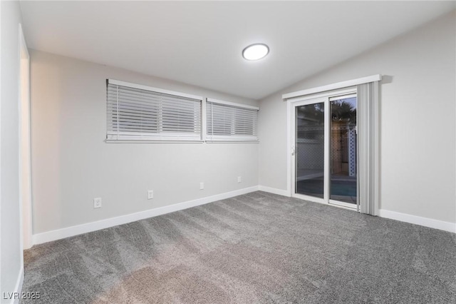 carpeted empty room with baseboards and vaulted ceiling