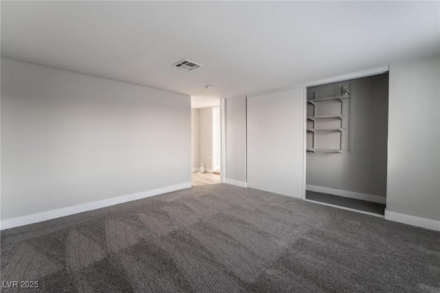 carpeted spare room featuring visible vents and baseboards