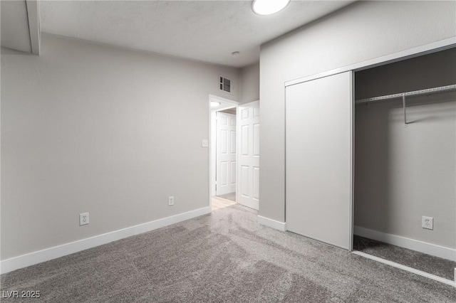 unfurnished bedroom with a closet, carpet flooring, baseboards, and visible vents