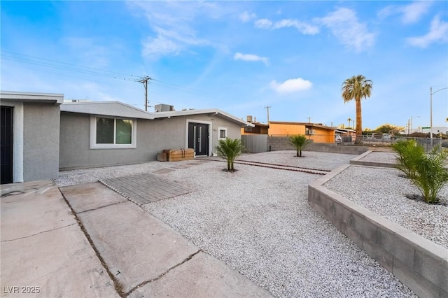 rear view of house featuring a patio area, a fenced backyard, and stucco siding