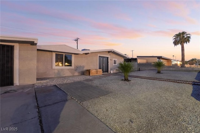 ranch-style home with a patio area, fence, and stucco siding