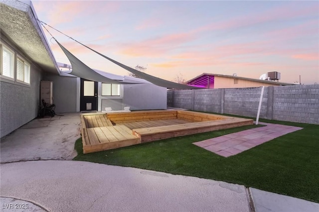 yard at dusk with central air condition unit, a patio area, and fence