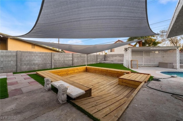 wooden terrace featuring a patio and a fenced backyard