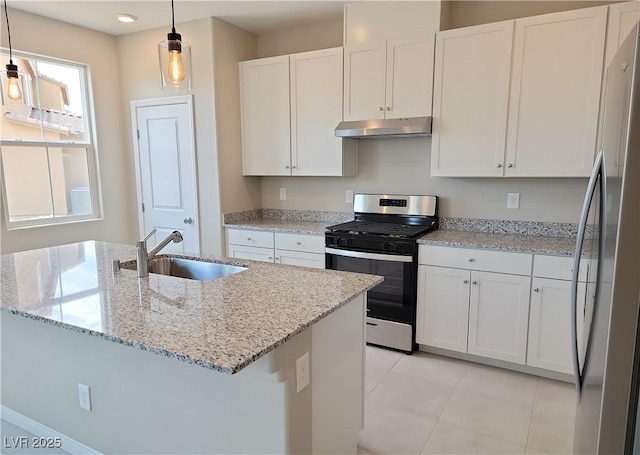 kitchen featuring white cabinetry, light tile patterned flooring, under cabinet range hood, appliances with stainless steel finishes, and a sink