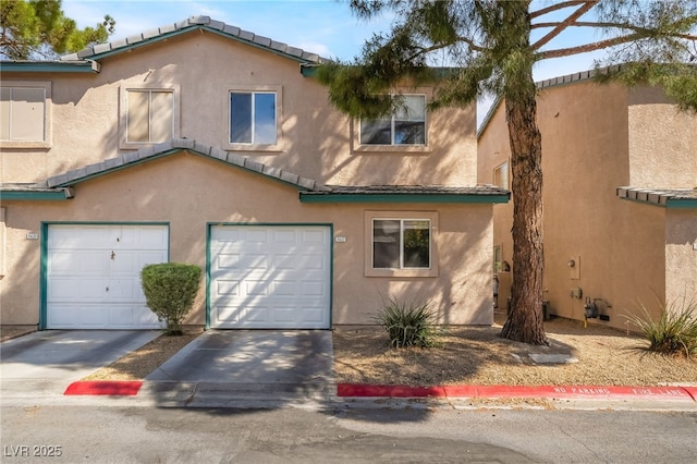 multi unit property featuring concrete driveway, stucco siding, and a garage