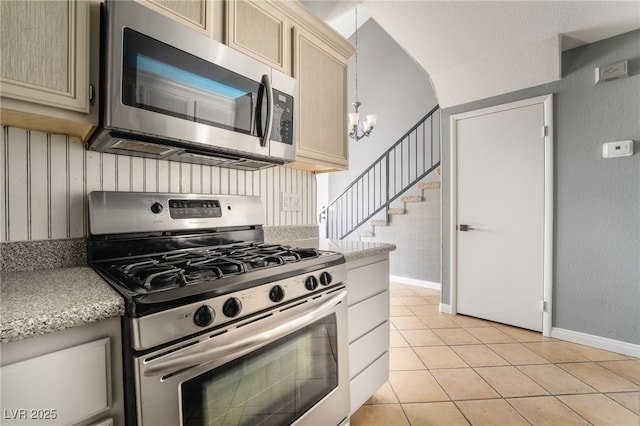 kitchen with a chandelier, light tile patterned flooring, light countertops, stainless steel appliances, and baseboards