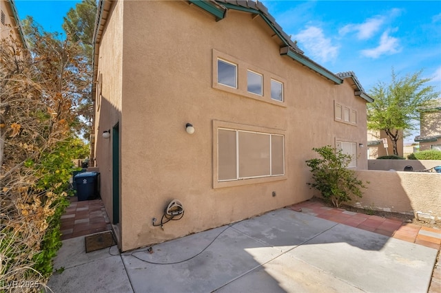 view of side of home featuring a patio and stucco siding