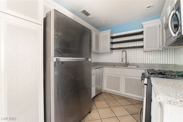 kitchen with light countertops, open shelves, visible vents, stainless steel appliances, and a sink