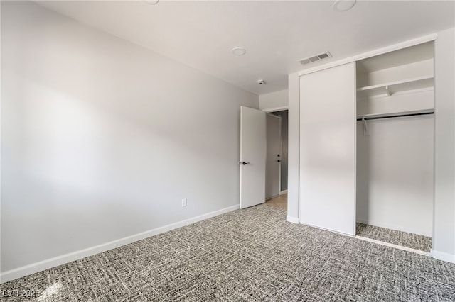 unfurnished bedroom featuring a closet, carpet flooring, baseboards, and visible vents