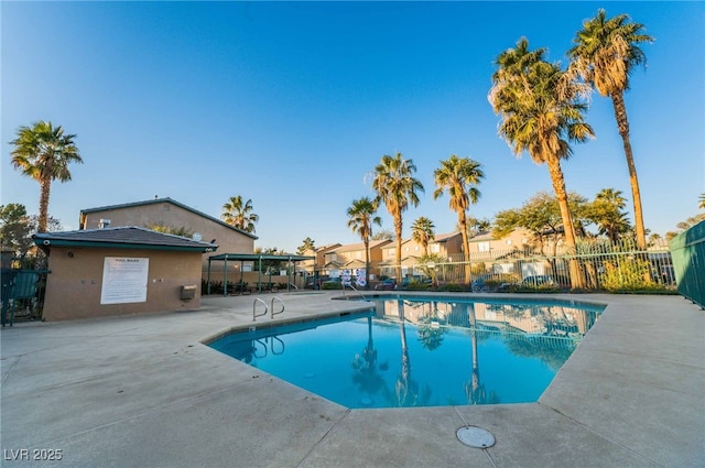 pool with a patio area and fence