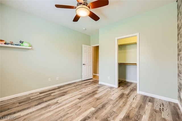 8318 Sonora Del Sol St, Las Vegas, NV 89113 - unfurnished bedroom featuring wood finished floors, baseboards, a ceiling fan, a walk in closet, and a closet
