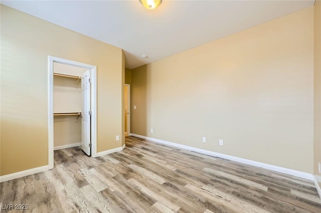 8318 Sonora Del Sol St, Las Vegas, NV 89113 - unfurnished bedroom with wood finished floors, baseboards, a closet, and a walk in closet