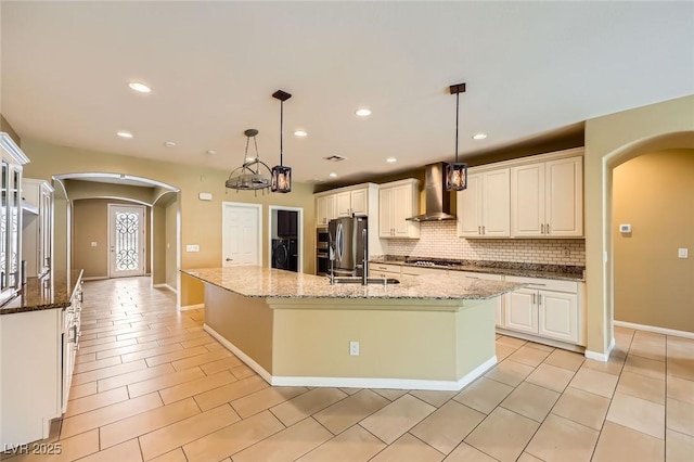 8318 Sonora Del Sol St, Las Vegas, NV 89113 - kitchen with arched walkways, wall chimney exhaust hood, decorative backsplash, gas cooktop, and recessed lighting