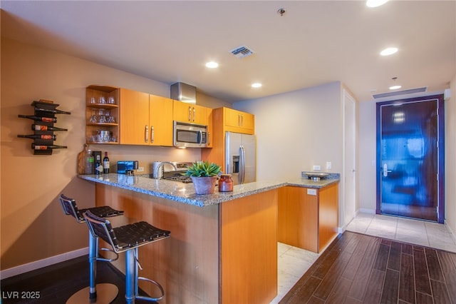 4525 Dean Martin Dr Unit 1103, Las Vegas, NV 89103 - kitchen featuring visible vents, a peninsula, baseboards, light stone counters, and stainless steel appliances