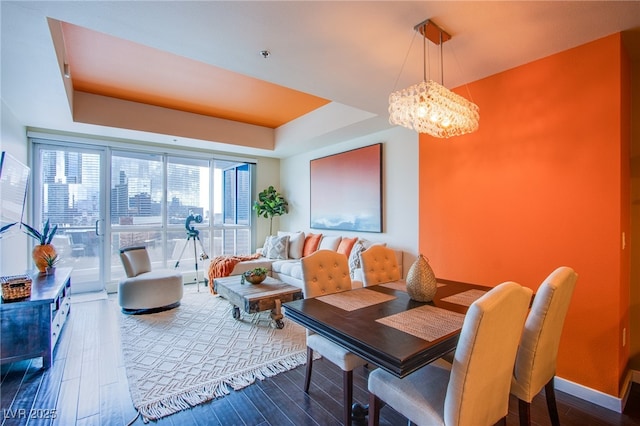4525 Dean Martin Dr Unit 1103, Las Vegas, NV 89103 - dining area featuring baseboards, a tray ceiling, wood finished floors, and a notable chandelier
