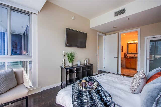 4525 Dean Martin Dr Unit 1103, Las Vegas, NV 89103 - bedroom featuring baseboards, ensuite bathroom, wood finished floors, and visible vents
