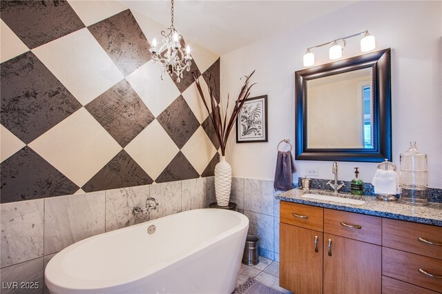 4525 Dean Martin Dr Unit 1103, Las Vegas, NV 89103 - bathroom featuring a notable chandelier, tile walls, a soaking tub, and vanity