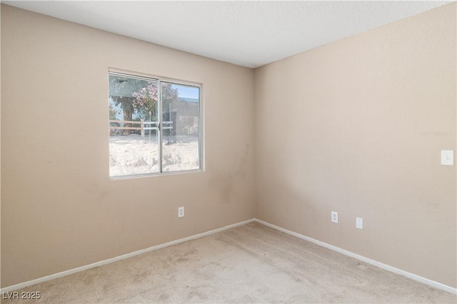 carpeted spare room with baseboards