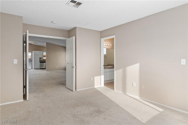 spare room with visible vents, light colored carpet, and baseboards