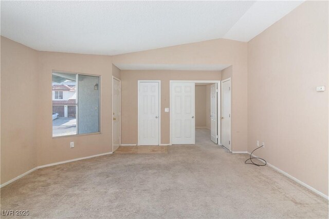 interior space with vaulted ceiling and baseboards