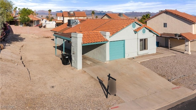 exterior space with a mountain view, driveway, stucco siding, and a tiled roof