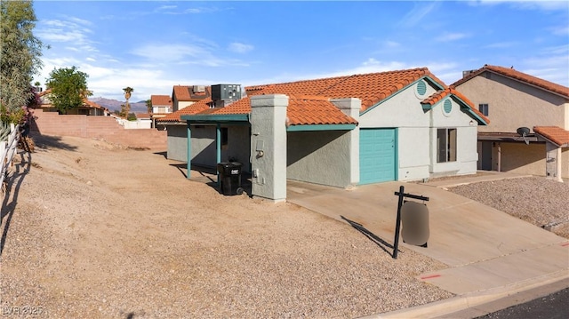 view of front facade featuring fence, stucco siding, and a tiled roof