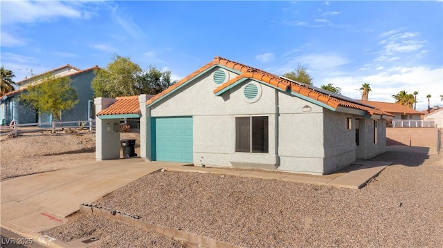 view of front of home with fence, concrete driveway, stucco siding, and an attached garage