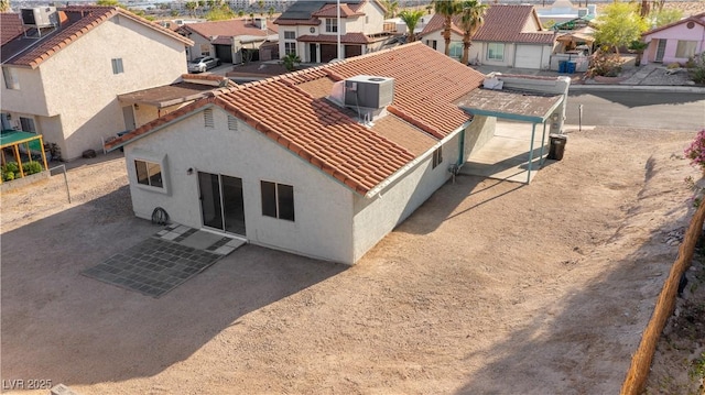 rear view of property with a residential view, stucco siding, and a tiled roof