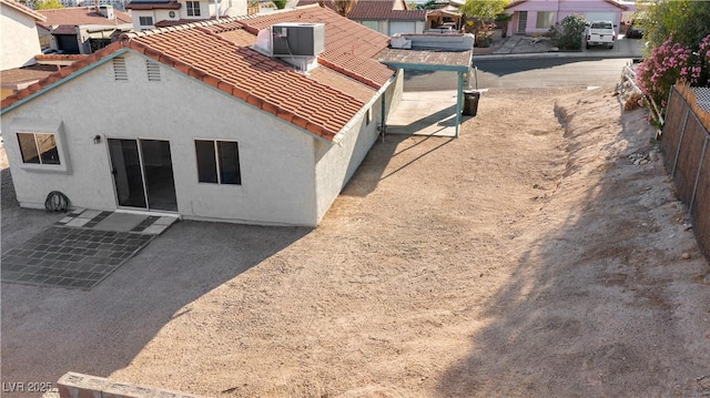 back of property featuring stucco siding, fence, a residential view, a tile roof, and a patio area