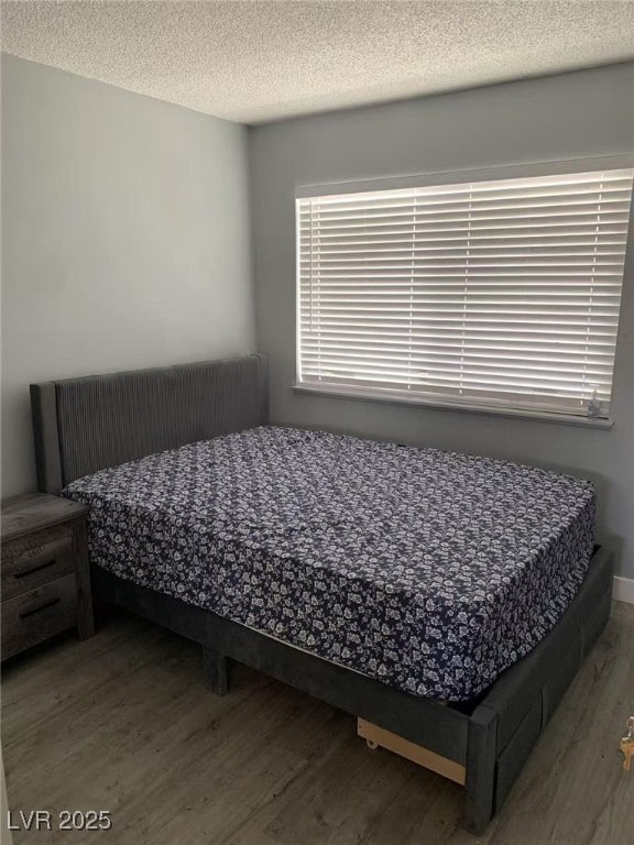 bedroom featuring a textured ceiling and wood finished floors