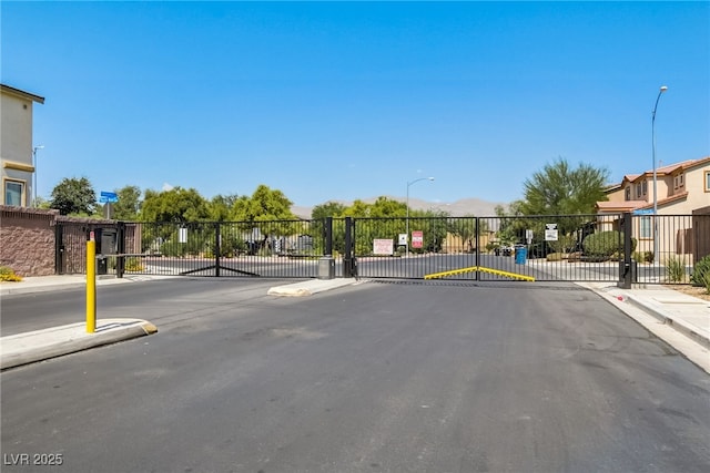 448 Bright Moon Ave, North Las Vegas, NV 89084 - view of asphalt road featuring sidewalks, a gate, street lighting, and curbs