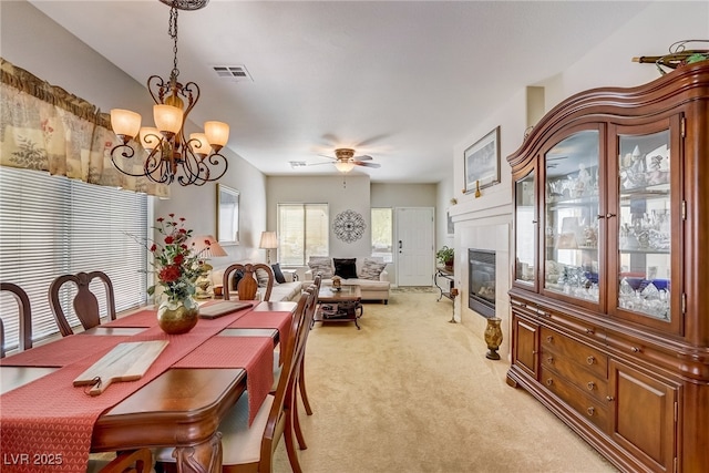 448 Bright Moon Ave, North Las Vegas, NV 89084 - dining room with light carpet, a chandelier, a tiled fireplace, and ceiling fan