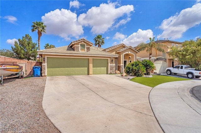 4878 Friar Tuck Ave, Las Vegas, NV 89130 - view of front of property featuring concrete driveway, stone siding, an attached garage, and stucco siding