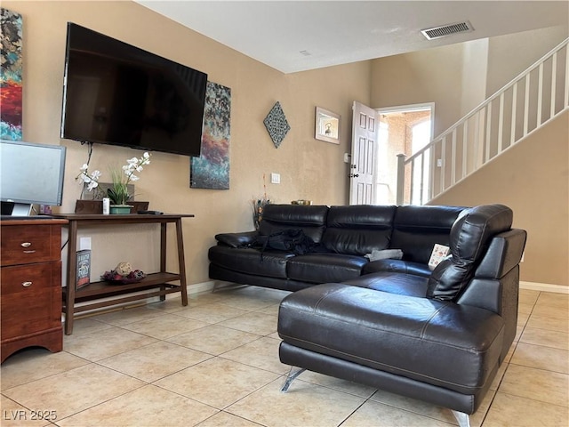 living area with stairs, light tile patterned floors, visible vents, and baseboards