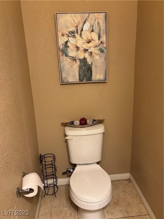 bathroom with tile patterned floors, baseboards, and toilet