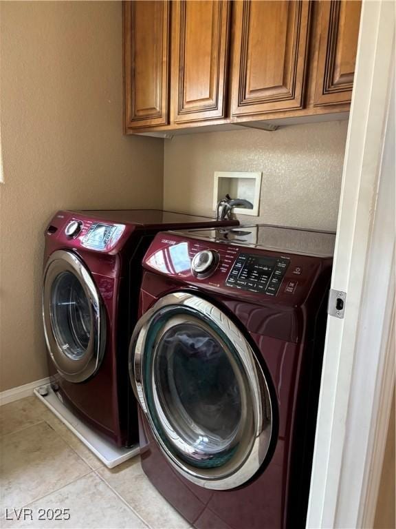 laundry room with tile patterned floors, separate washer and dryer, and cabinet space
