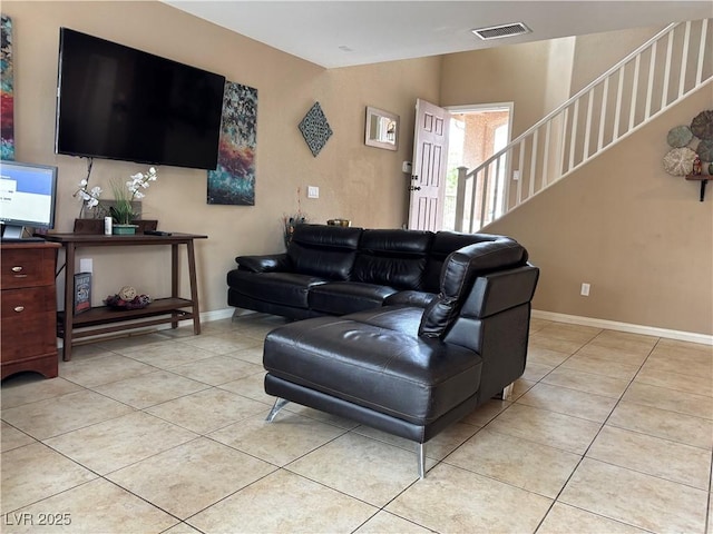 living room featuring stairway, light tile patterned floors, visible vents, and baseboards