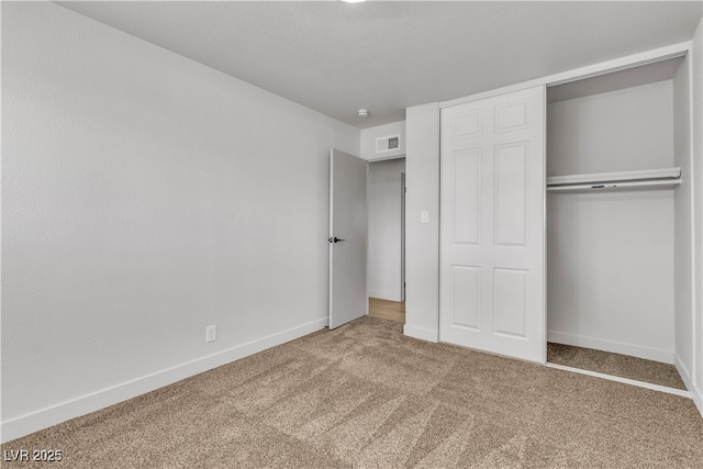 unfurnished bedroom with a closet, baseboards, carpet, and visible vents