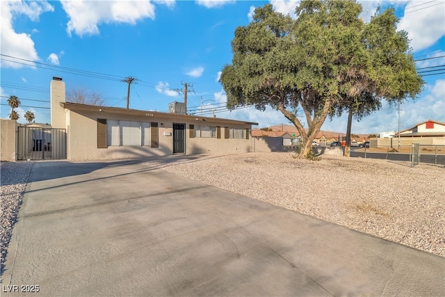 ranch-style home featuring stucco siding, fence, and a gate