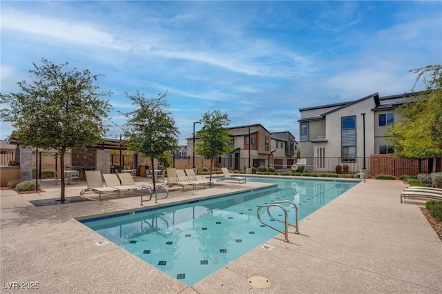 pool with a residential view, a patio area, and fence