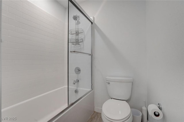 full bathroom featuring enclosed tub / shower combo, baseboards, toilet, and wood finished floors