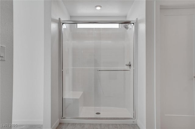 bathroom featuring baseboards and a stall shower