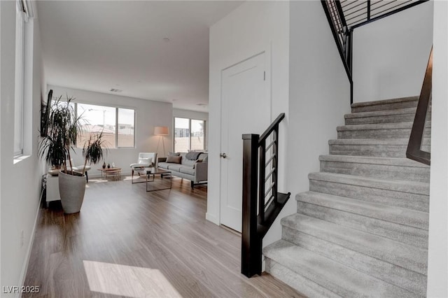 stairway with baseboards and wood finished floors